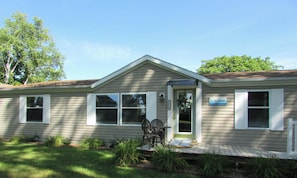 A single-story house with a front porch, a small garden, and a sign that reads "The Gerway."