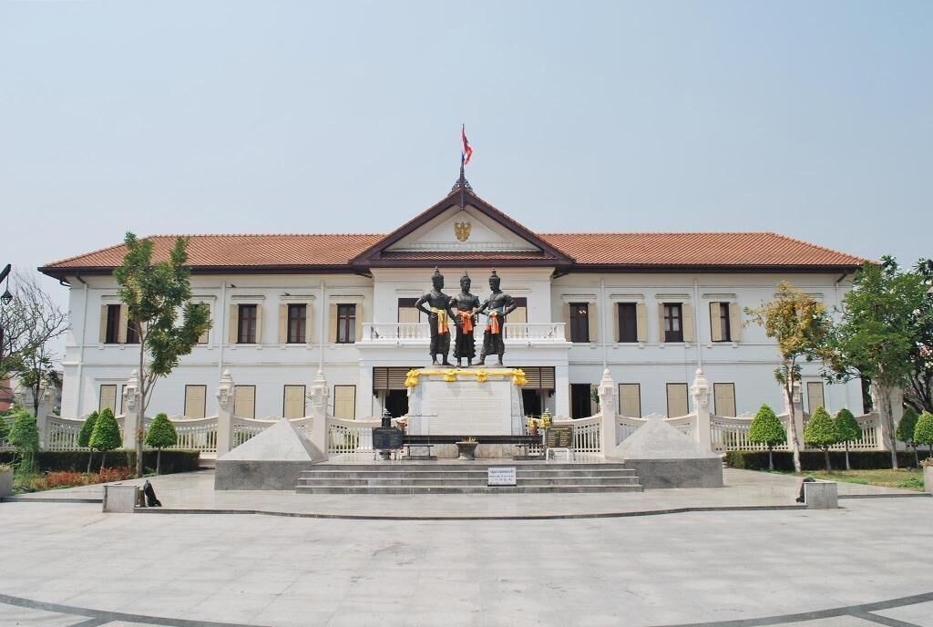 A large building with a central statue, a flag on top, and a symmetrical facade.