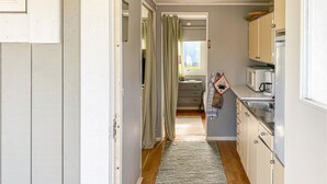 A narrow hallway leading to a kitchen with a microwave, coffee maker, and a sink. - Awesome home in Falkenberg with WiFi (Falkenberg)