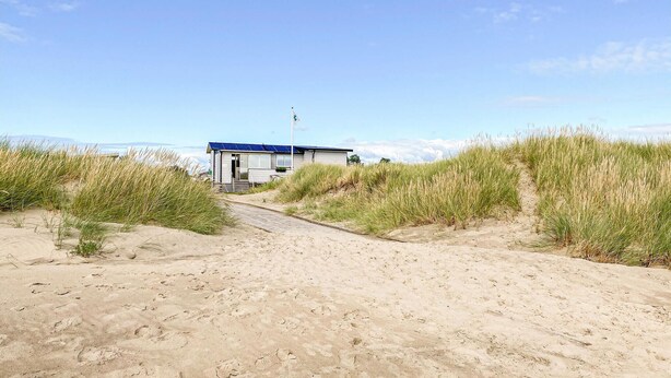 A sandy beach path leading to a small building with a blue roof, surrounded by tall grass. - Awesome home in Falkenberg with WiFi (Falkenberg)