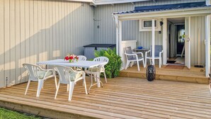A deck with a table and chairs, a covered seating area, and a door leading inside. - Awesome home in Falkenberg with WiFi (Falkenberg)