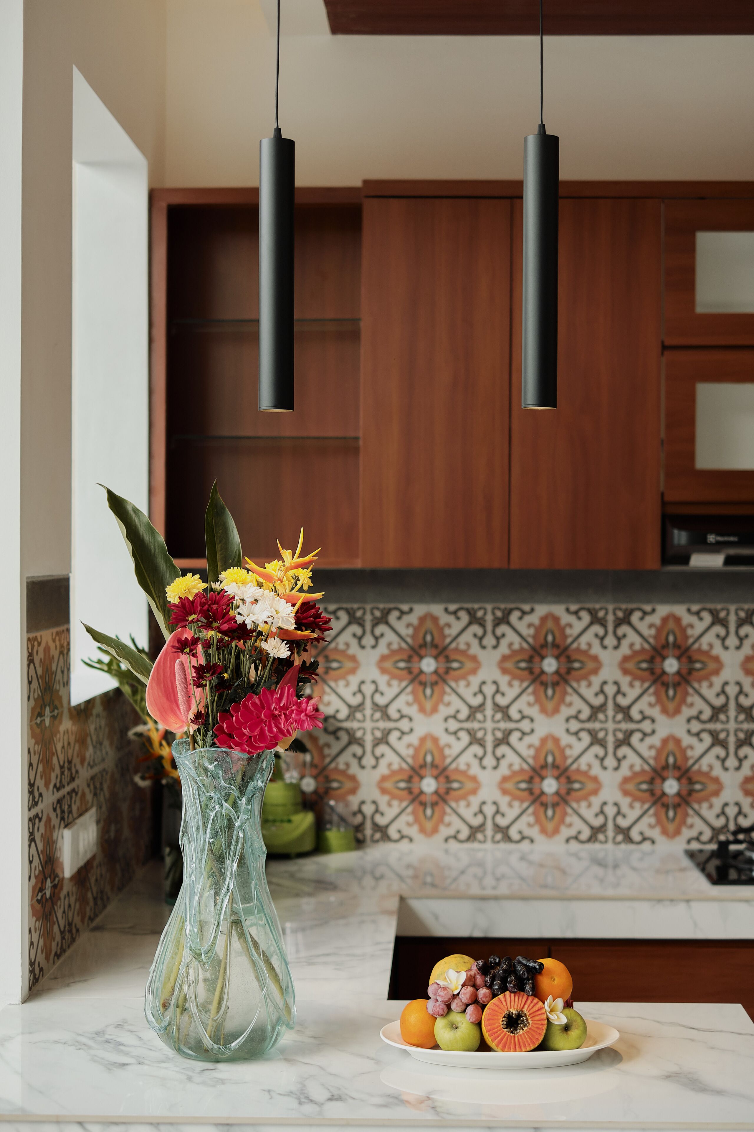Una cocina con armarios de madera, un salpicadero decorativo y una encimera de mármol.
