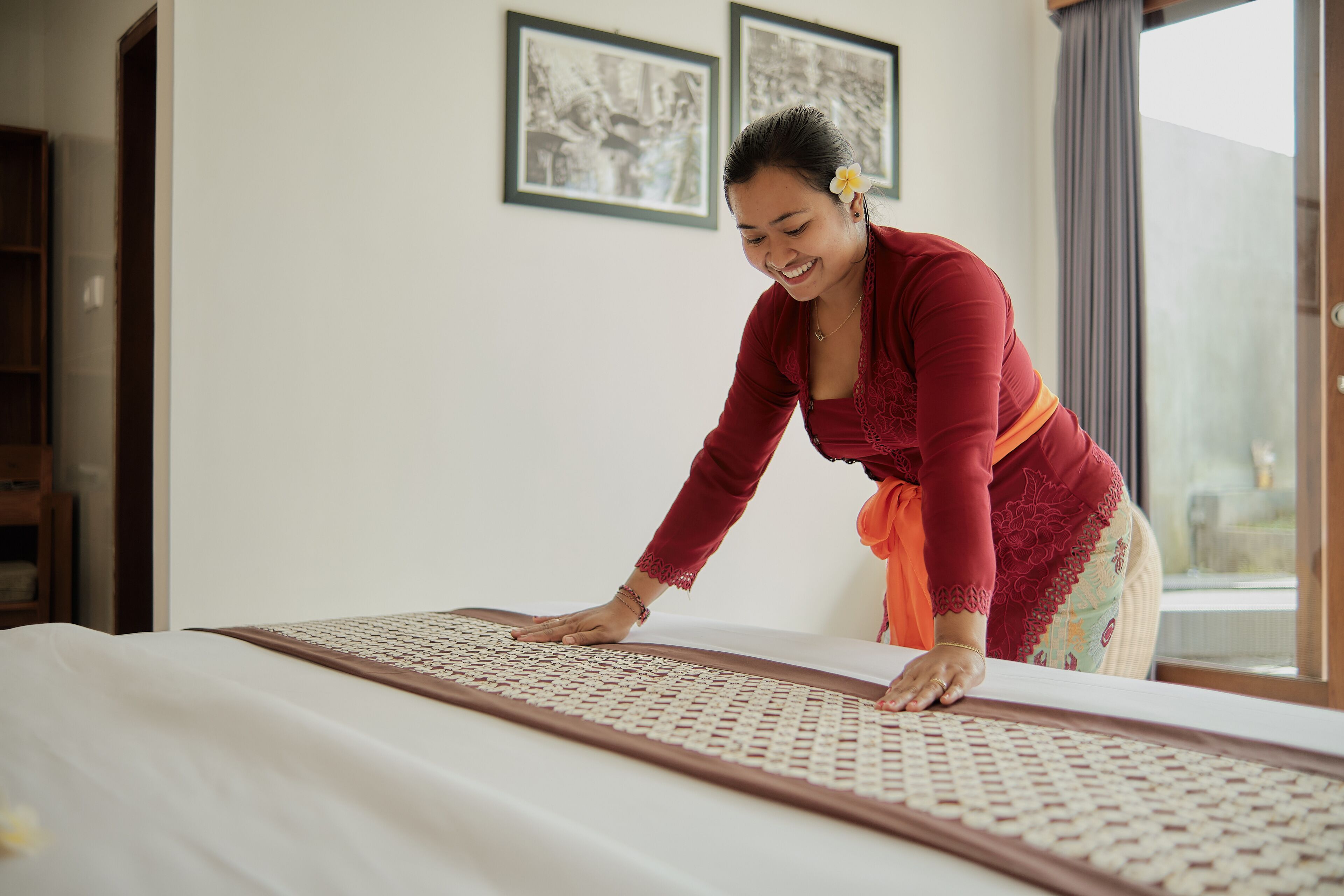 A person performing a massage on a bed with a patterned mat.