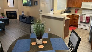 A modern kitchen with wooden cabinets, a white stove, and a microwave. - Weekend Wine Getaway (Temecula)