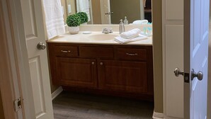 A bathroom with a double vanity, a large mirror, and a potted plant. - Weekend Wine Getaway (Temecula)