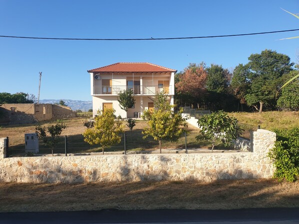 A two-story building with a red-tiled roof, surrounded by a stone wall and a metal fence. - Impeccable 2-Bed House in Privlaka, Croatia (Privlaka)