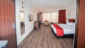 Une chambre d’hôtel avec un grand lit, un bureau, une chaise et une petite table.