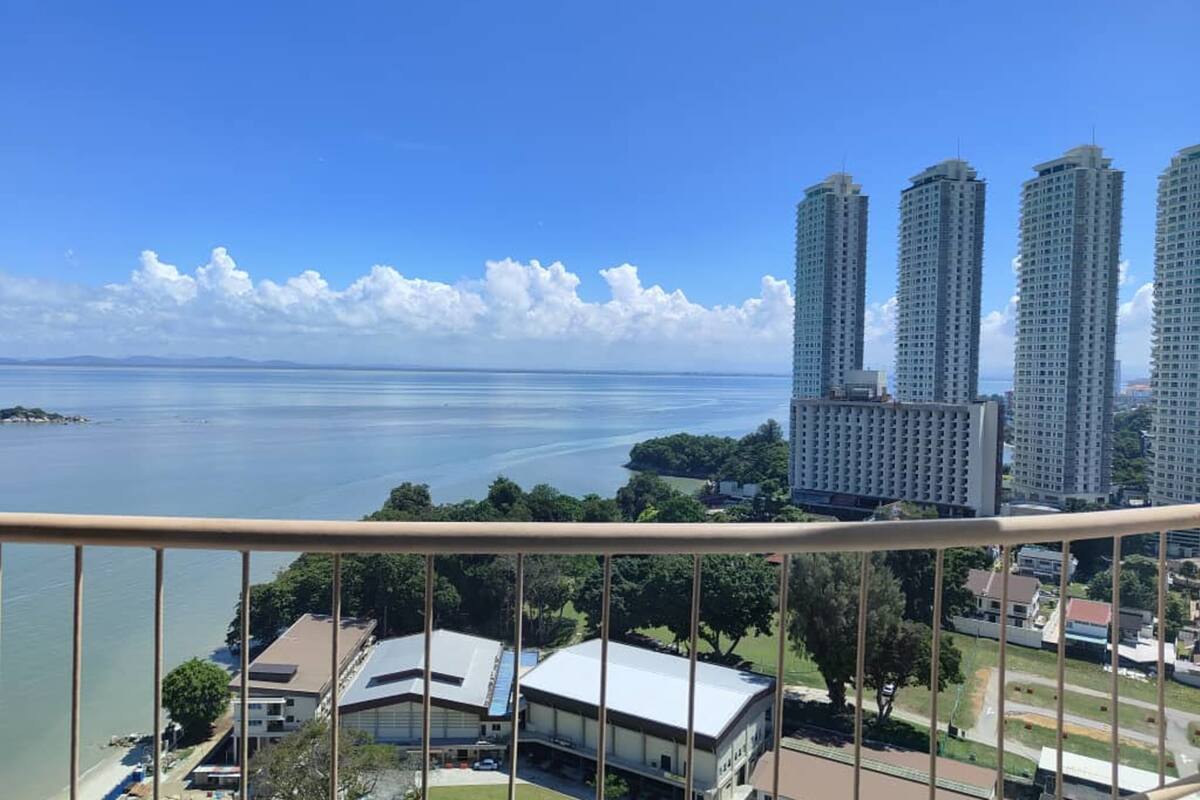 A high-rise building with multiple floors, a clear view of the surrounding area, and a body of water in the background.