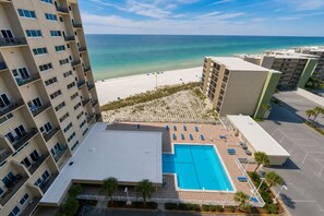 A hotel with a swimming pool, beach view, and multiple balconies. - Oceanfront, By 30A, Pool, Sauna, Boat Slips FREE! (Panama City Beach)