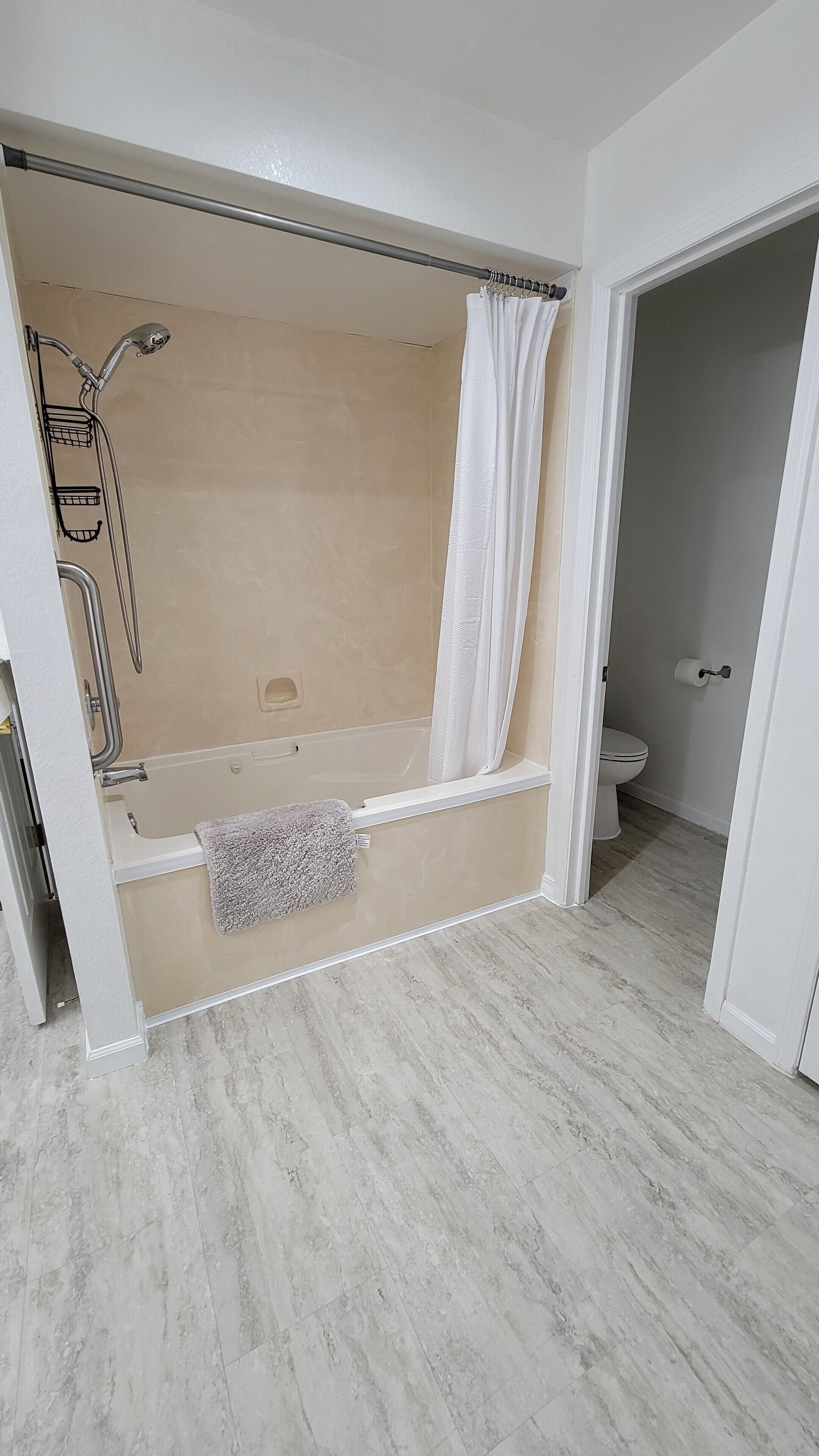 A bathroom with a bathtub, shower, and toilet.