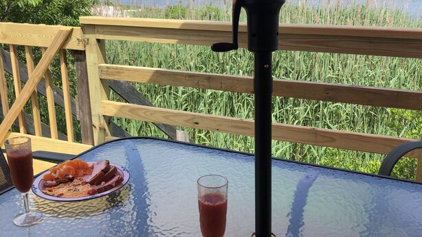 A table with food and drinks on a deck overlooking a body of water. - Unbelievable October Deals - Booking through 10/31/26 (Davis Park)