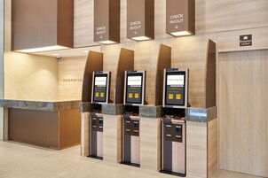 A check-in/out station with digital kiosks and a baggage locker.