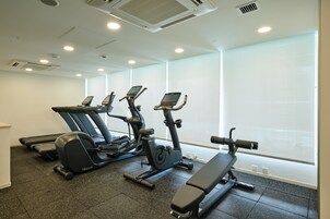 A gym with treadmills, an elliptical, and a bench.