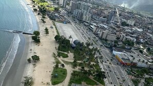 Luftaufnahme einer Küstenstadt mit Strand, Straßen und Gebäuden.