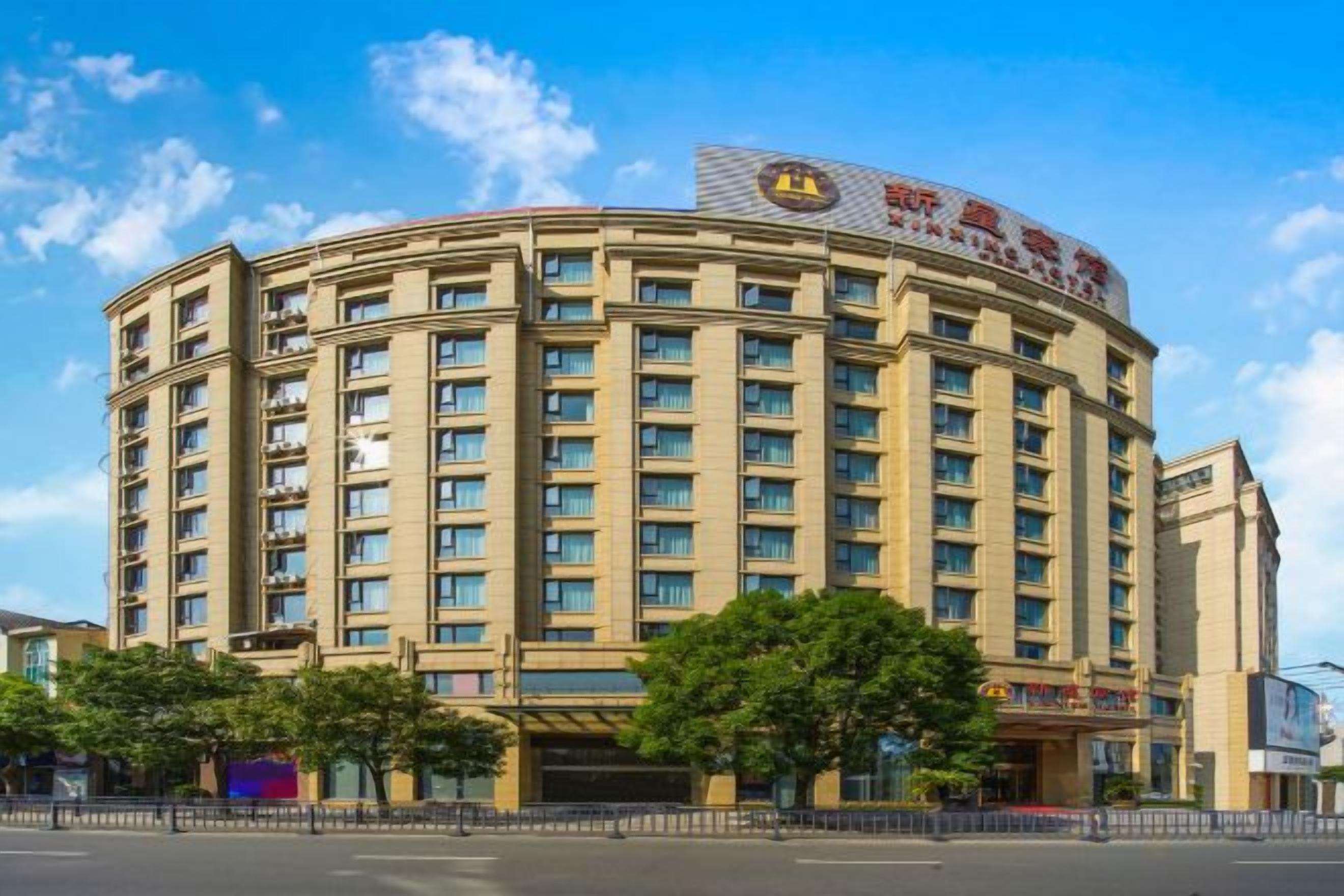 A multi-story hotel with a curved facade, numerous windows, and a prominent sign on the top.