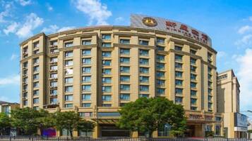 A multi-story hotel with a curved facade, numerous windows, and a prominent sign on the top.