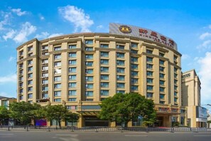 A multi-story hotel with a curved facade, numerous windows, and a prominent sign on the top. - Xinxing Jingming Hotel (Ninghai)