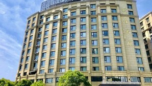 A multi-story hotel with a curved facade, numerous windows, and a sign indicating it is a Nova hotel. - Xinxing Jingming Hotel (Ninghai)