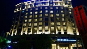 Un hôtel à plusieurs étages, doté d’une enseigne lumineuse et d’une architecture moderne.