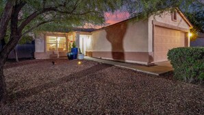A residential house with a garage, a front door, and a driveway. - Near Kino / Fenced / Outdoor Living / 3BR & 2BA (Tucson)