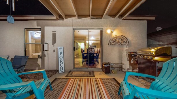 A porch with two blue chairs, a grill, and a sign that reads "PORCH". - Near Kino / Fenced / Outdoor Living / 3BR & 2BA (Tucson)