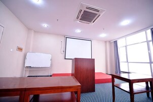 Un salón de conferencias con una pizarra, un atril y un amplio ventanal.