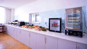 A kitchen with a built-in oven, microwave, and a display of food items. - Lejia Hotel (Bazhou Shengfang International Furniture Expo City) (Bazhou)