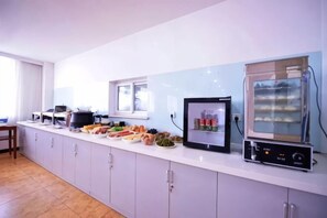 Una cocina con horno empotrado, microondas y una variedad de alimentos.