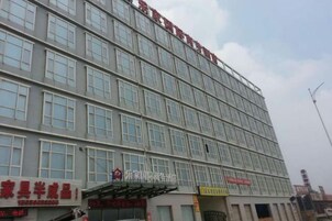 Un edificio de varios pisos con fachada plana, amplias ventanas y carteles de varios negocios.