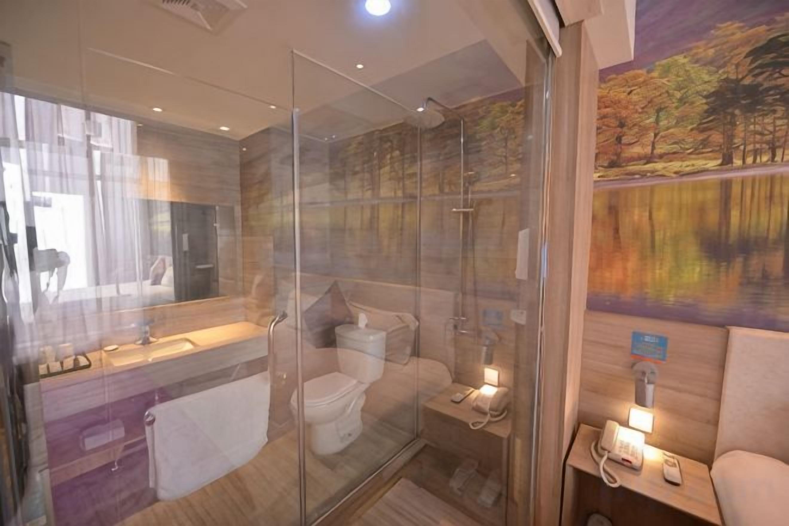 A modern bathroom with a glass shower enclosure, a toilet, and a vanity with a mirror.