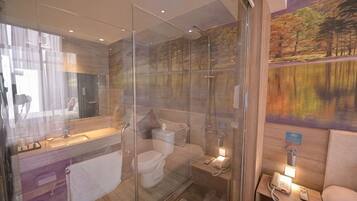A modern bathroom with a glass shower enclosure, a toilet, and a vanity with a mirror.
