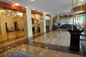 A spacious lobby with a polished marble floor, a reception desk, and a staircase leading to upper floors. - Jinta Hotel (Jinta)