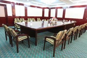 A conference room with a large rectangular table surrounded by chairs, carpeted floor, and a whiteboard on the wall. - Jinta Hotel (Jinta)