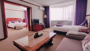 A hotel room with two beds, a TV, a coffee table, and a sofa. - Jinta Hotel (Jinta)