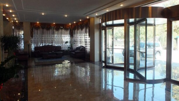 A lobby with a polished floor, a seating area with sofas, and a glass door leading outside. - Jinta Hotel (Jinta)