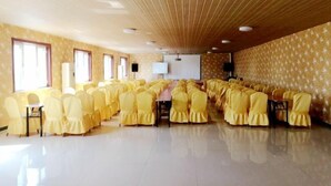 A conference room with rows of yellow chairs, a long table, and a wooden ceiling. - Taidawenquanbinguan (Yongqing)