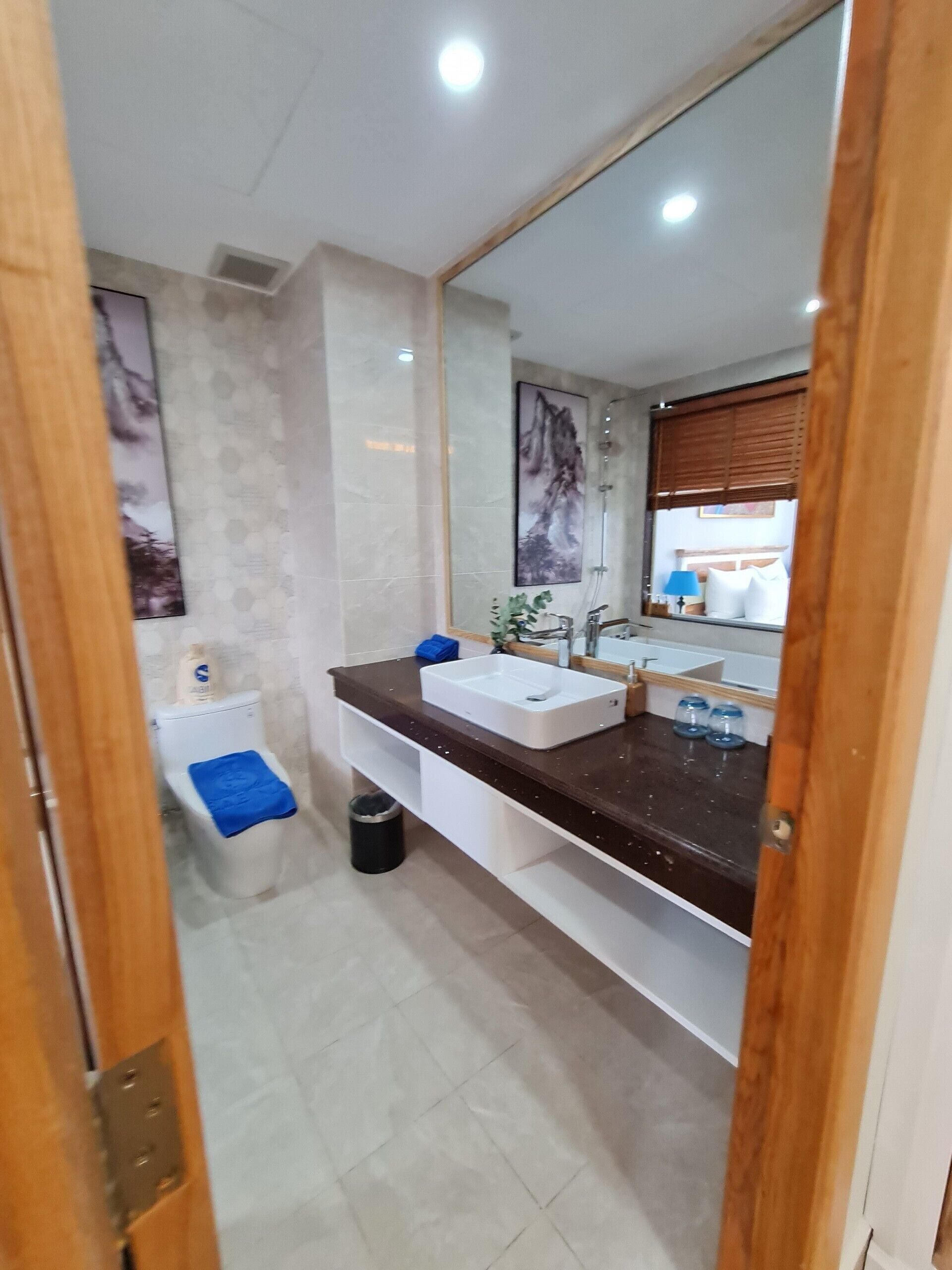 A modern bathroom with a large mirror, a white sink, and a shower.