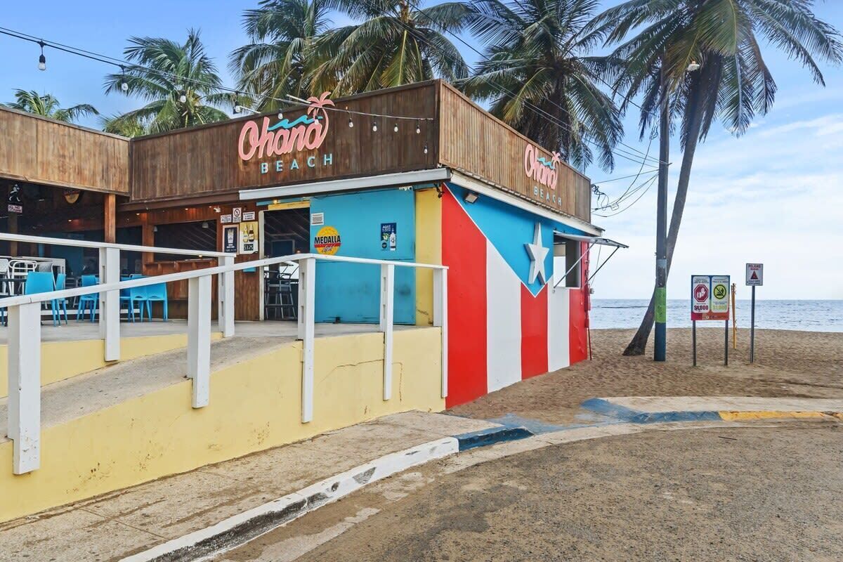 Ein Restaurant direkt am Strand namens 'Ohana Beach' mit Außenbereich und Blick auf den Ozean.