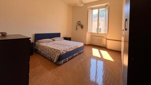 A bedroom with a bed, a dresser, a window with blinds, and a radiator. - In the center of Porretta Terme (Porretta Terme)