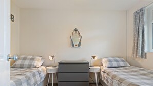 A bedroom with two beds, a dresser, a mirror, and bedside lamps. - Ballyroan - Peaceful Dog Friendly Cottage (Tenby)