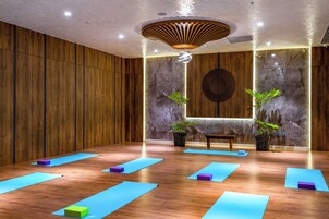 Un estudio de yoga con paredes de madera, una pared de mármol y una lámpara en el techo.
