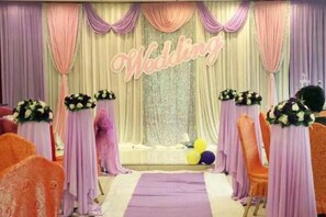 A wedding stage with a 'Wedding' sign, floral centerpieces, and a purple aisle. - Jiangxia Hotel (Liuzhou)