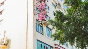 Un edificio de varios pisos con un cartel llamativo que indica un hotel.