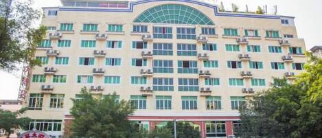 A multi-story hotel with a prominent entrance and several balconies.