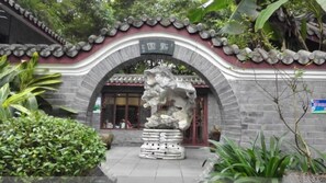 A traditional building with a stone facade, an arched entrance, and a stone sculpture in the center. - Jiangxia Hotel (Liuzhou)