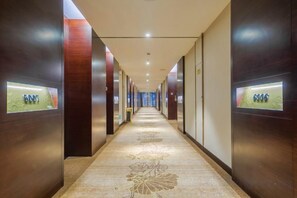 A hotel corridor with a carpeted floor and wooden walls. - Liuyiju International Hotel Yongfeng (Yongfeng)