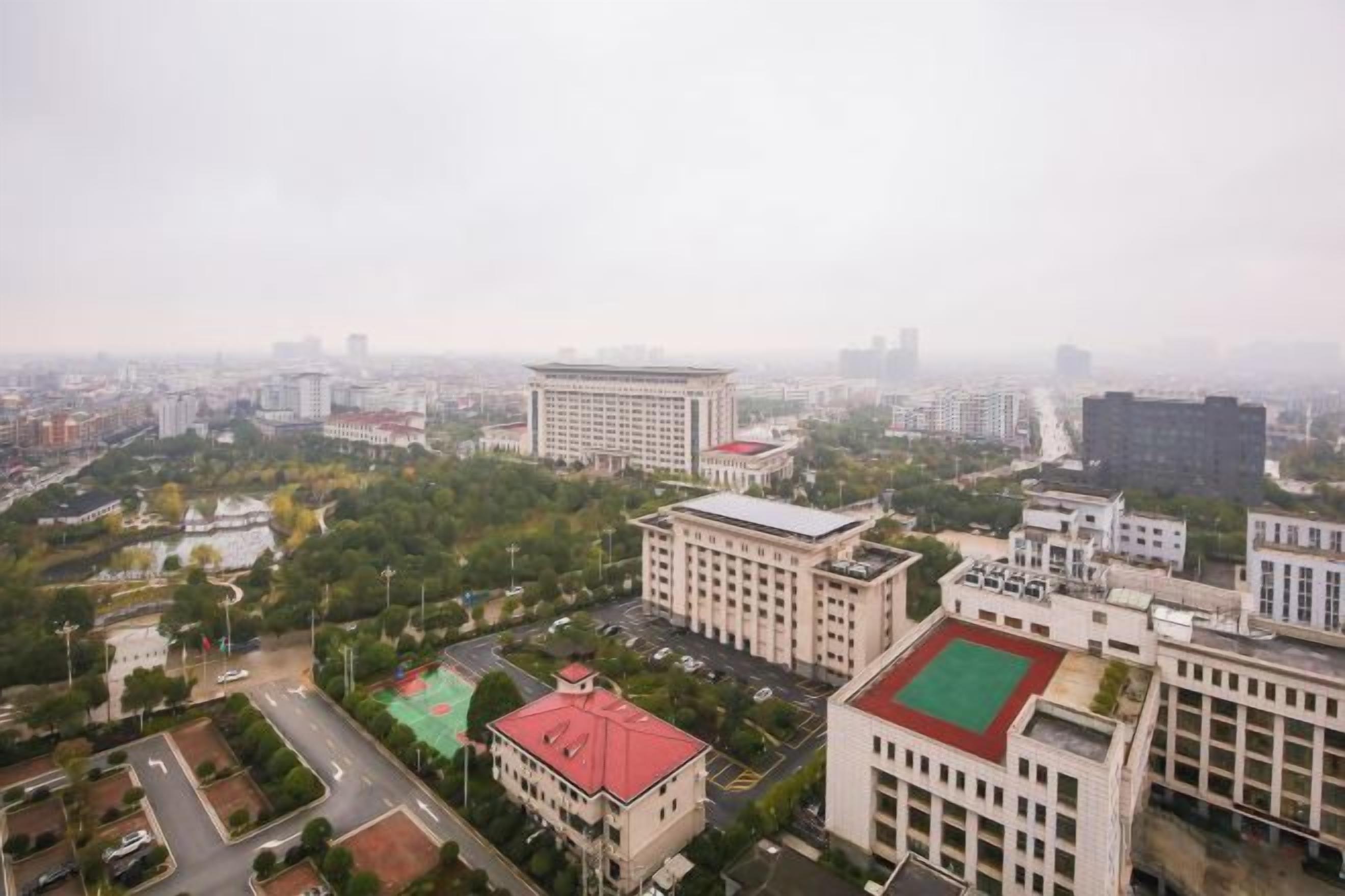 A cityscape with buildings, roads, and greenery.