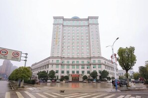 A large, multi-story building with a symmetrical facade, a central entrance, and a flat roof. - Liuyiju International Hotel Yongfeng (Yongfeng)