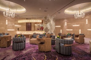 A lobby with round tables, sofas, and a reception desk. - Liuyiju International Hotel Yongfeng (Yongfeng)