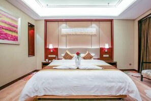 A hotel room with a large bed, two bedside tables, a nightstand, a wall-mounted artwork, and a ceiling light. - Liuyiju International Hotel Yongfeng (Yongfeng)
